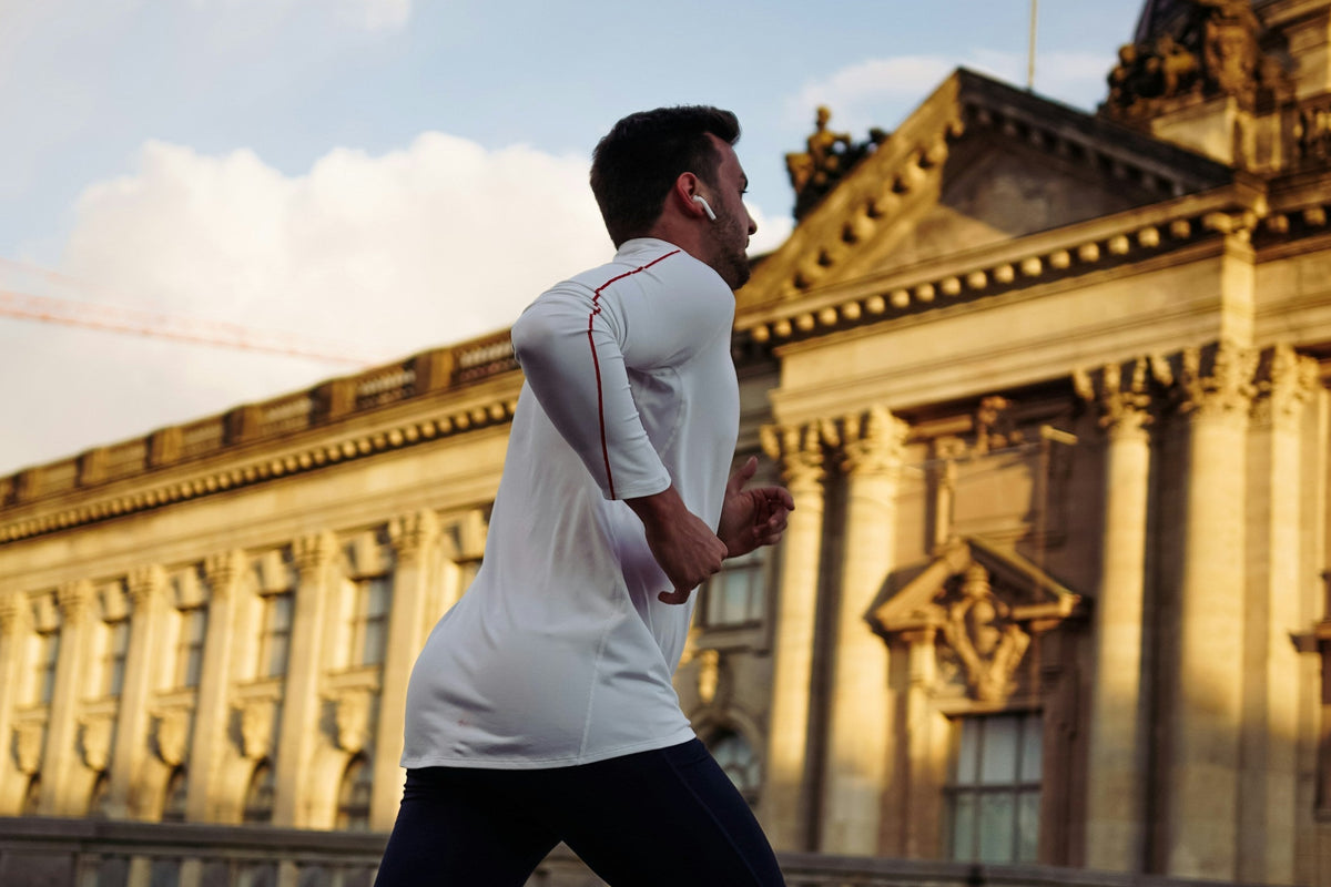 Man running in front of a historic building with a flag